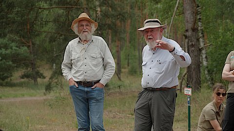 Zwei M&auml;nner im Gespr&auml;ch miteinander. Im Hintergrund sind B&auml;ume zu erkennen. Die M&auml;nner sind Prof. Michael Succow und Hannes Knapp
