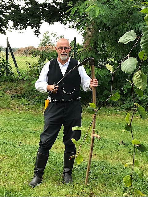 Foto von Uwe K&ouml;rner - Sensen-Workshop-Leiter - mit Sense im Garten stehend